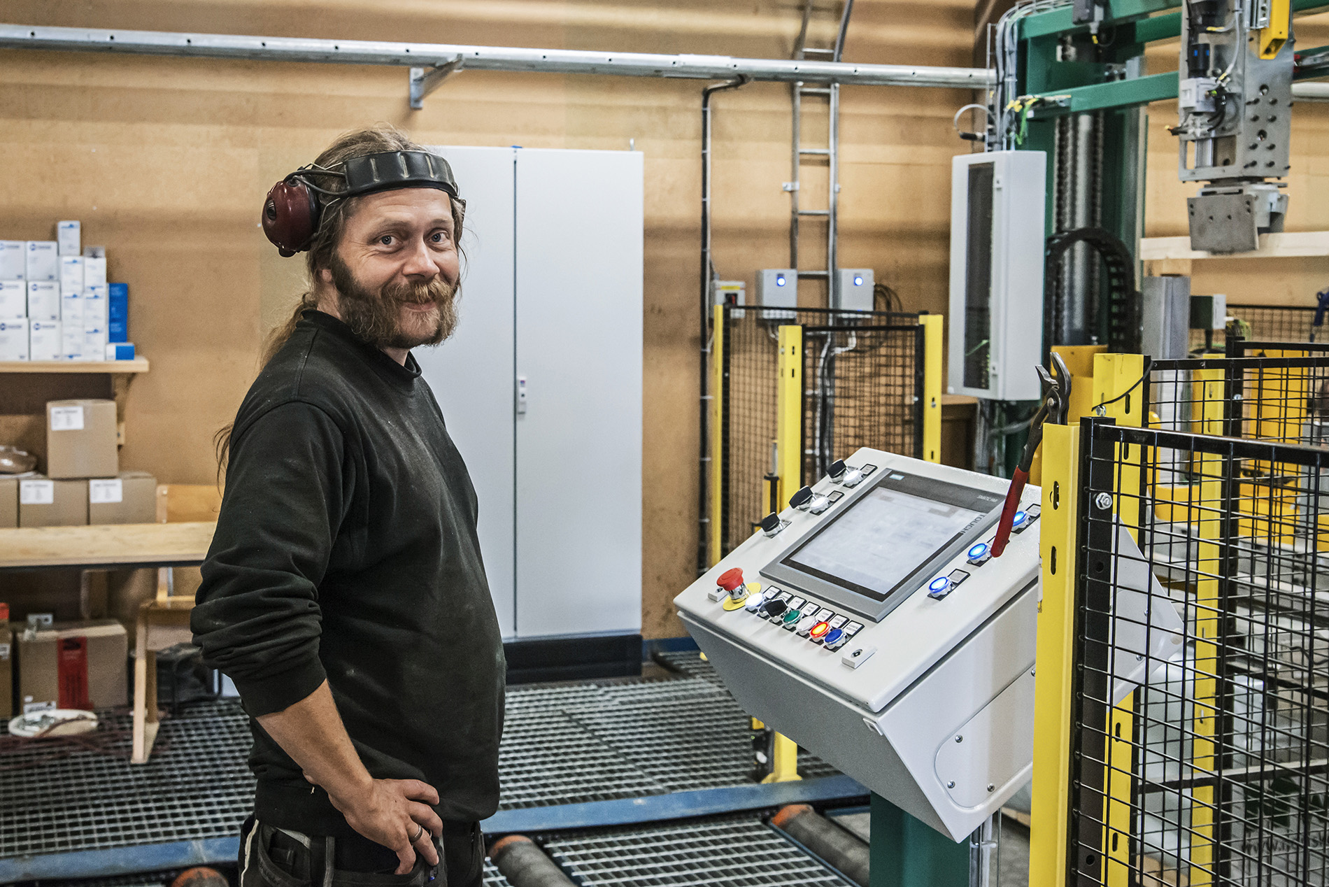 Mand arbejder med maskiner i industrivirksomhed
