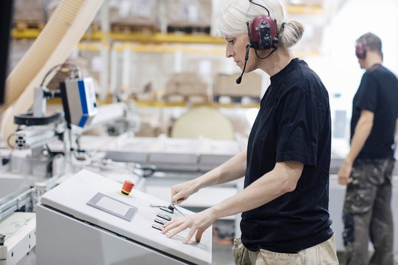 Kvinde arbejder på industrimaskine